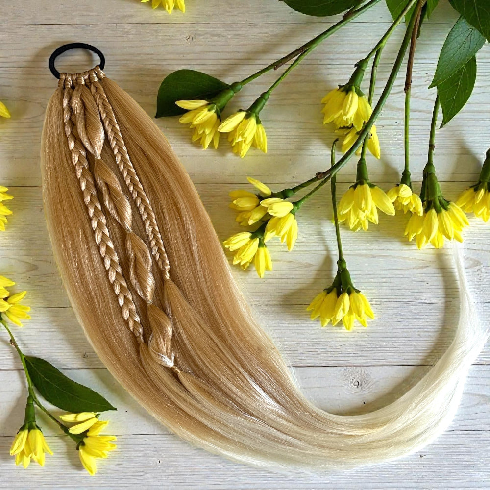 Blonde braided hair extensions with yellow flowers on a wooden surface