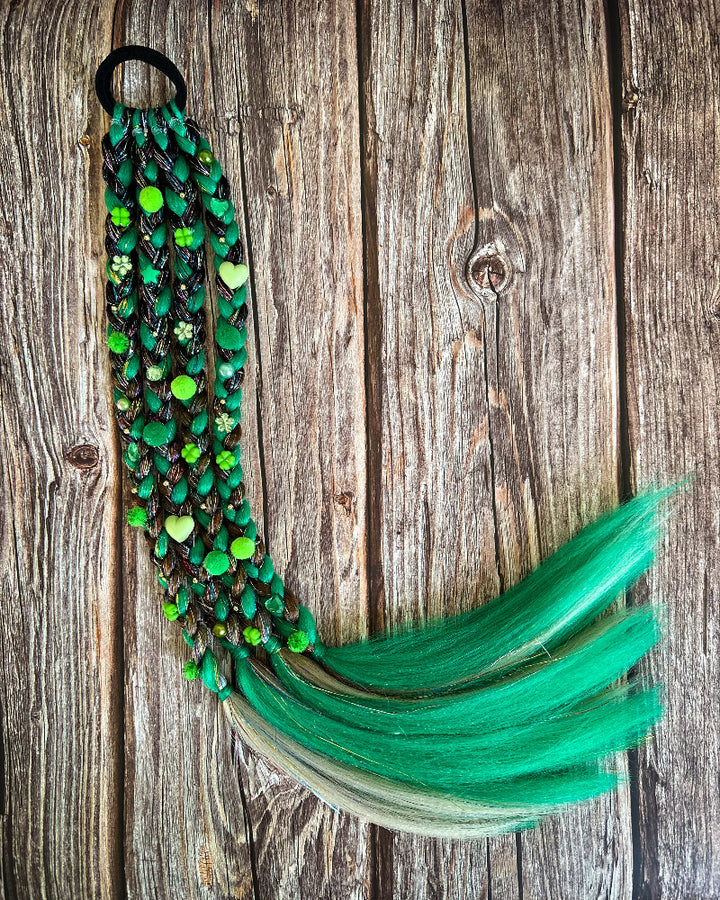 Green beaded hair tie with feathers on a wooden background