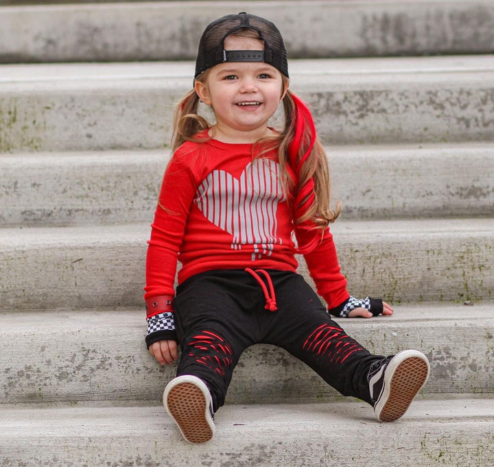 Model wearing clip in hair extensions for kids in curly texture red