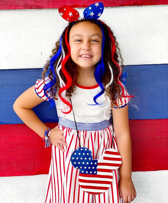 Young girl models USA patriot pack of clip-in hair extensions in red white and blue